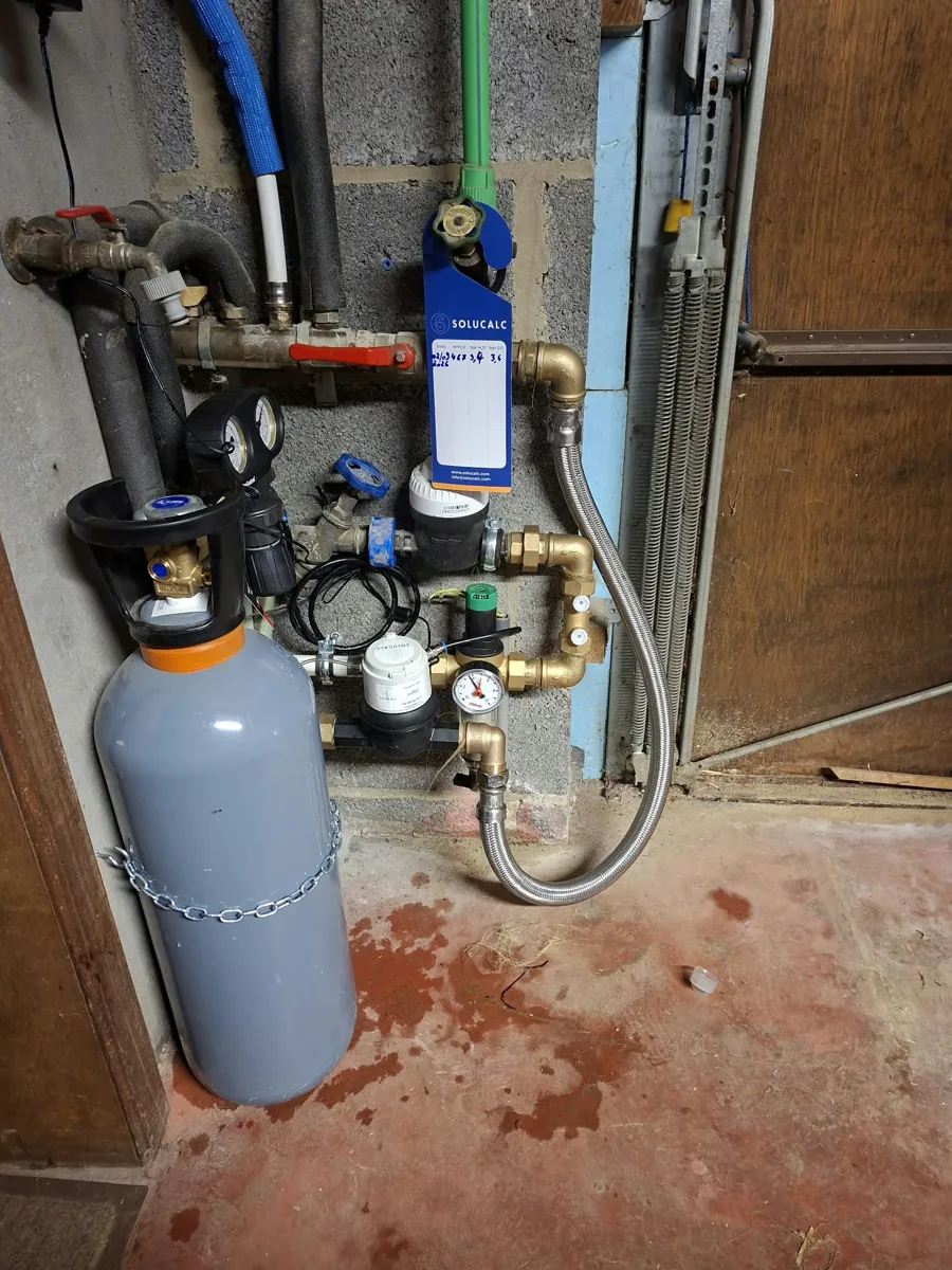 Système anticalcaire au CO2 installé par LDS Technics après le compteur d'eau, avec sa bouteille de CO2 sécurisée